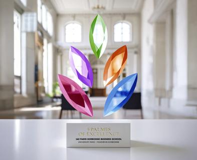 Trophée des 5 palmes de couleurs (bleu, orange, verte, violet, rose) Eduniversal derrière un fond blanc avec des colonnes