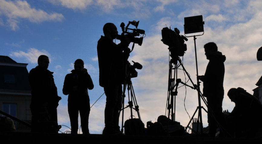Tournage de film avec des personnes au loin face à un couché de soleil