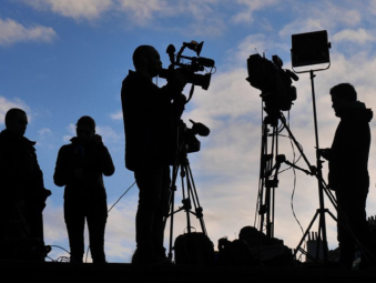 Tournage de film avec des personnes au loin face à un couché de soleil